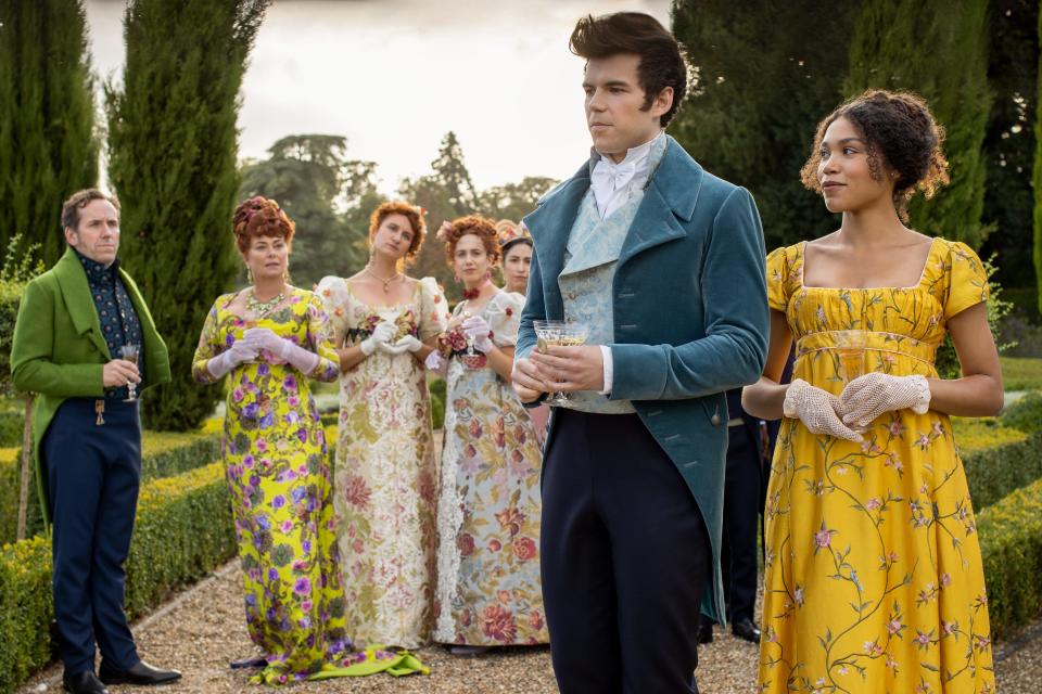 L-R: Ben Miller as Lord Featherington, Polly Walker as Portia Featheringnton, Bessie Carter as Prudence Featherington, Harriet Cains as Phillipa Featherington, Luke Newton as Colin Bridgerton, and Ruby Barker as Marina Thompson in Season 1 of "Bridgerton".