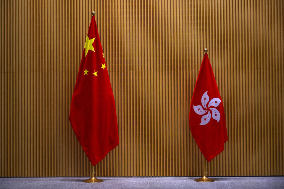 FILE - In this Monday, March 22, 2021, file photo, a China national flag, left, and a Hong Kong flag are displayed at central government office in Hong Kong. A year after Beijing imposed a harsh national security law on Hong Kong, the civil liberties that raised hopes for more democracy are fading. (AP Photo/Vincent Yu, File)