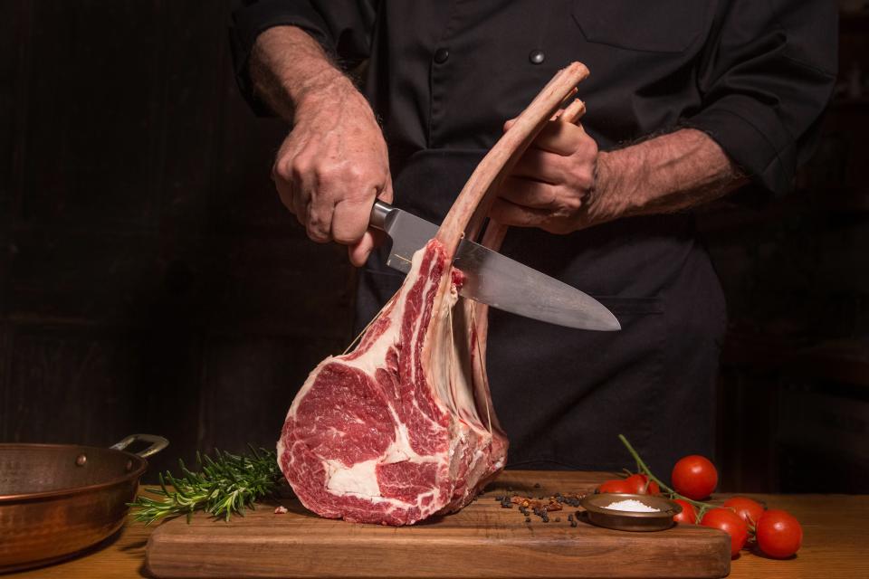 A chef cuts a ribeye steak. Greenpeace has urged countries to reduce meat consumption to help tackle the climate crisis (Getty)