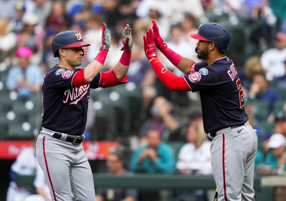 Washington Nationals' Lane Thomas, left, celebrates after his home run against Seattle Mariners starting pitcher Luis Castillo with teammate Luis Garcia during the first inning of a baseball game Monday, June 26, 2023, in Seattle. (AP Photo/Lindsey Wasson)