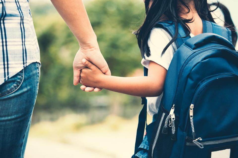 Midsection Of Mother Holding Daughter Hand While Taking Her To School