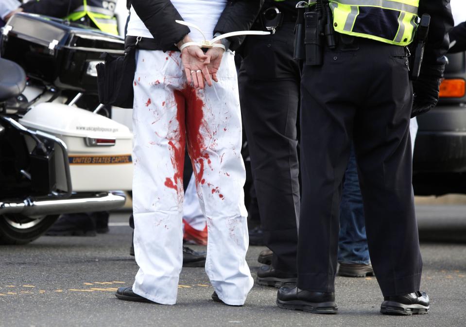U.S. Capitol Police arrest a pro-choice protester, with pants painted with red paint, for blocking the way of the anti-abortion March for Life at the U.S. Supreme Court building in Washington