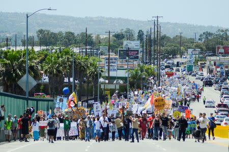 Demonstrators walk on the Pacific Coast highway during People's Climate March protest for the environment in the Wilmington neighborhood in Los Angeles, California, U.S. April 29, 2017. REUTERS/Andrew Cullen