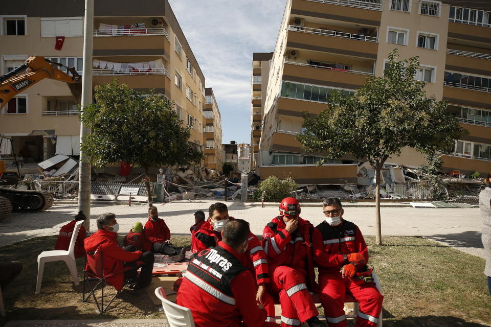 Member of rescue services take a break during search operations in the debris of a collapsed building for survivors in Izmir, Turkey, Sunday, Nov. 1, 2020. Rescue teams continue ploughing through concrete blocs and debris of collapsed buildings in Turkey's third largest city in search of survivors of a powerful earthquake that struck Turkey's Aegean coast and north of the Greek island of Samos, Friday Oct. 30, killing dozens Hundreds of others were injured.(AP Photo/Emrah Gurel)