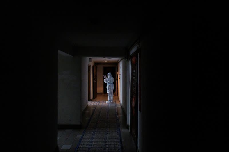A pandemic prevention worker in a protective suit stands in an apartment building that went into lockdown as coronavirus disease (COVID-19) outbreaks continue in Beijing