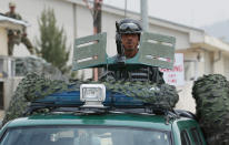 An Afghan policeman stands guard in his vehicle in front of the main gate of Cure International Hospital in Kabul, Afghanistan, Thursday, April 24, 2014. (AP Photo/Massoud Hossaini)