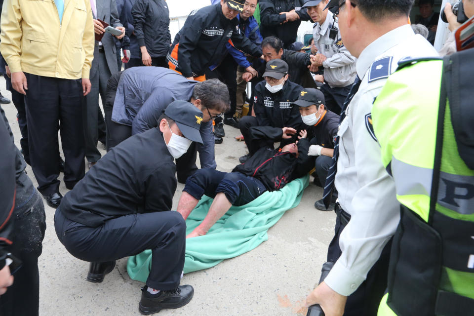 A rescued passenger from a ferry sinking off South Korea's southern coast, is carried by police and rescue teams on his arrival at Jindo port in Jindo, south of Seoul, South Korea, Wednesday, April 16, 2014. Dozens of rescue boats and helicopters are scrambling to save more than 470 people, including many high school students, caught on a ferry sinking off South Korea's southern coast, officials said. There are no immediate reports of causalities. (AP Photo/Park Chul-heung, Yonhap)