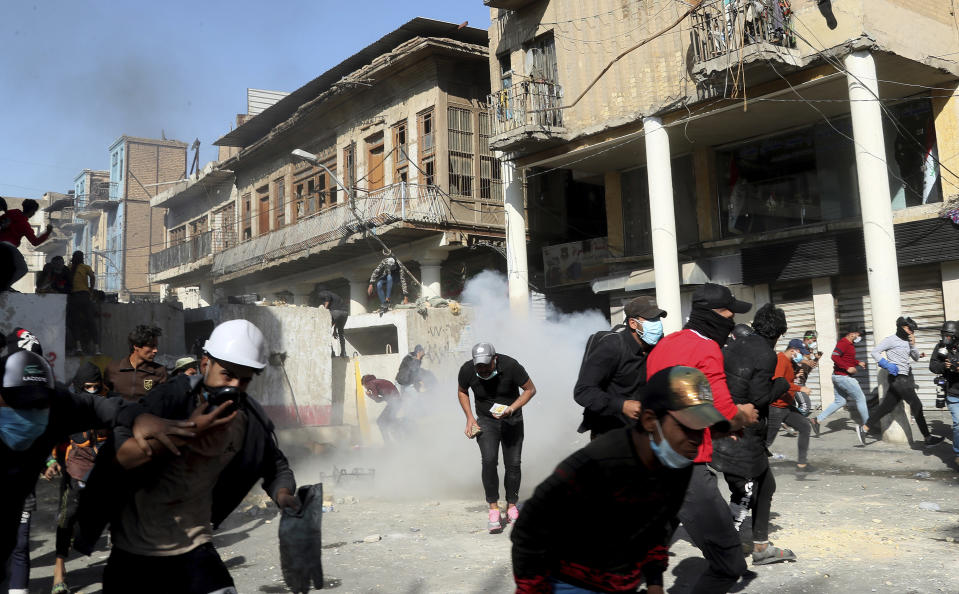 Riot police fire tear gas while blocking al-Rashid Street during clashes with anti-government demonstrators in Baghdad, Iraq, Friday, Nov. 22, 2019. Iraq's massive anti-government protest movement erupted Oct. 1 and quickly escalated into calls to sweep aside Iraq's sectarian system. Protesters occupy several Baghdad squares and parts of three bridges in a standoff with security forces. (AP Photo/Hadi Mizban)