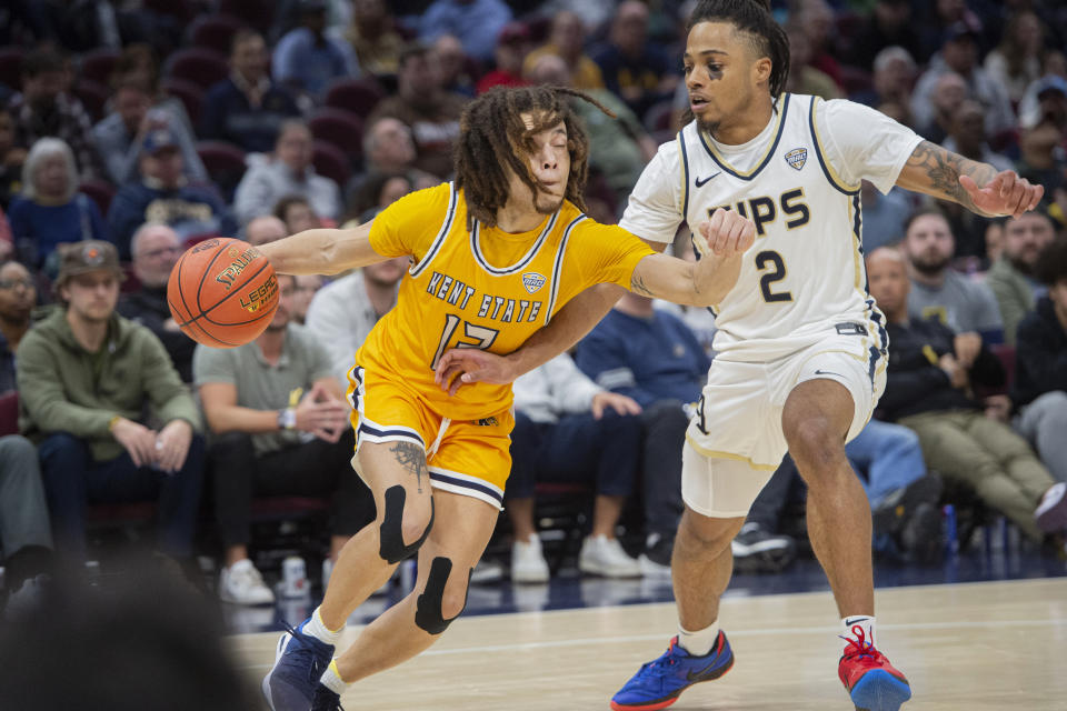 Kent State's Jalen Sullinger, left, drives as Akron's Greg Tribble (2) defends during the second half of an NCAA college basketball game in the championship of the Mid-American Conference tournament, Saturday, March 16, 2024, in Cleveland. (AP Photo/Phil Long)