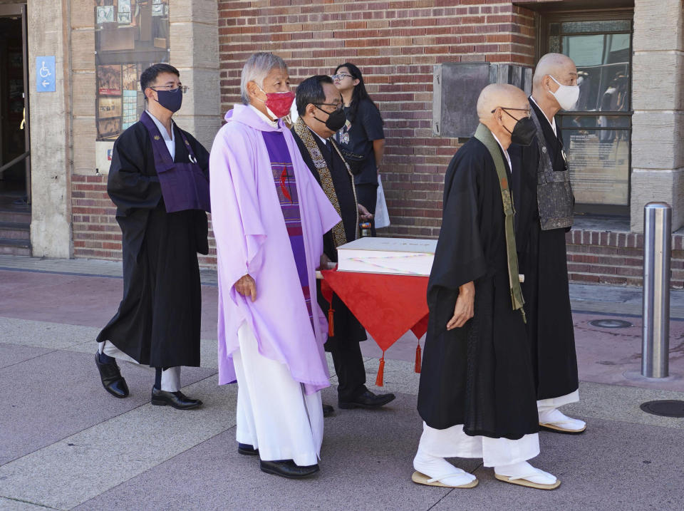 Duncan Ryūken Williams and clergy carry the Ireichō at the Japanese American National Museum in Los Angeles on Sept. 24, 2022. The book lists the names of the more than 125,000 people who were detained in internment camps for Japanese Americans nationwide during World War II. (Nobuyuki Okada/JANM via AP)