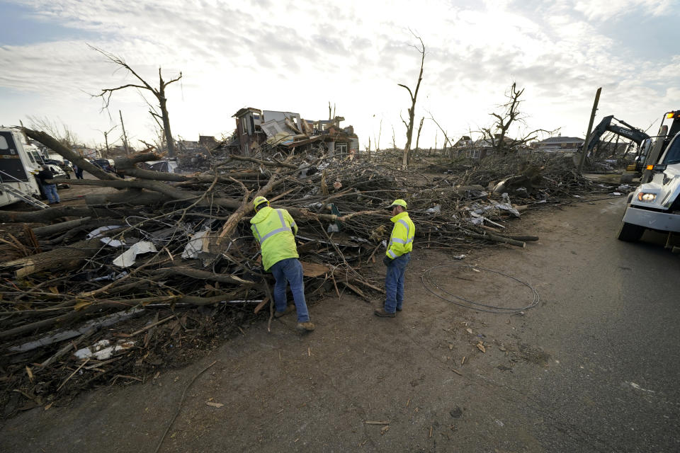 Workers cut debris in the aftermath of tornadoes that tore through the region, in Mayfield, Ky., Tuesday, Dec. 14, 2021. (AP Photo/Gerald Herbert)