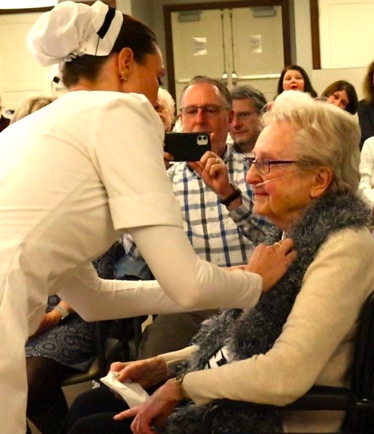 Retired nurse Betty Beecher, 99, of Weymouth, is presented with a Nightingale pin honoring her service from the NVNA and Hospice at Fairing Way in Weymouth, where she lives. Her son, Mark, is in the background.