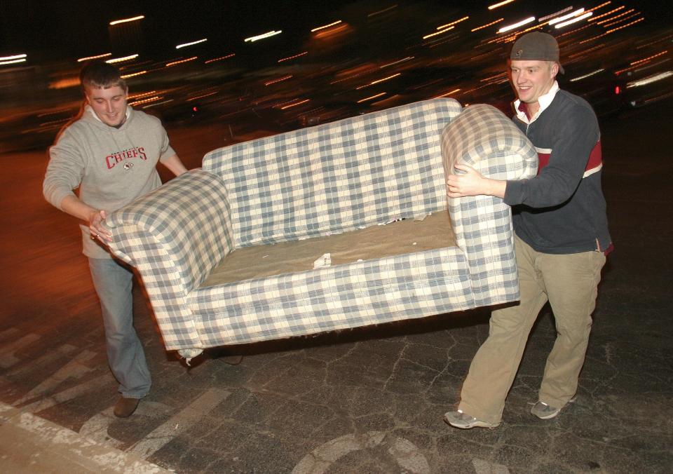 MSU students Matt Turner, left, and Scott Pierson move a couch across the parking lot at Hammons Student Center on Friday night. The Theta Chi members were among several dozen students who planned to spend the night camping out outside the arena waiting for a chance to buy student tickets for Saturday's game against Creighton. The pair said they planned to rely on a mix of poker, books, Ipods, and homework to pass the time overnight.