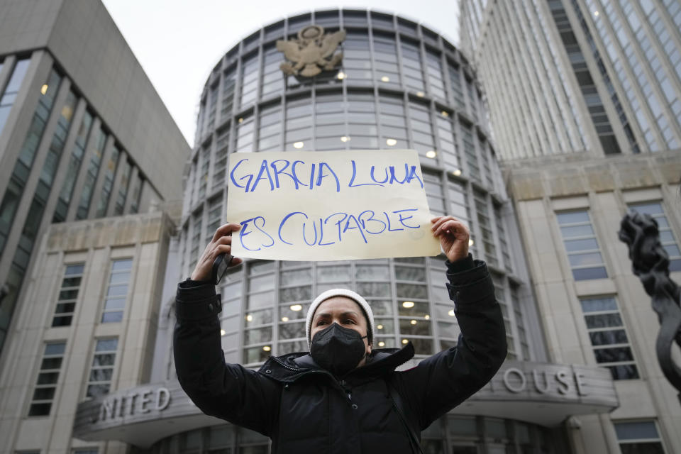 Una manifestante sostiene un letrero afuera de un tribunal federal de Nueva York, el martes 21 de febrero de 2023, momentos antes de que el exsecretario de Seguridad Pública de México, Genaro García Luna, fuera declarado culpable de aceptar sobornos para proteger a los violentos cárteles del narcotráfico a los que debía combatir. (AP Foto/John Minchillo)