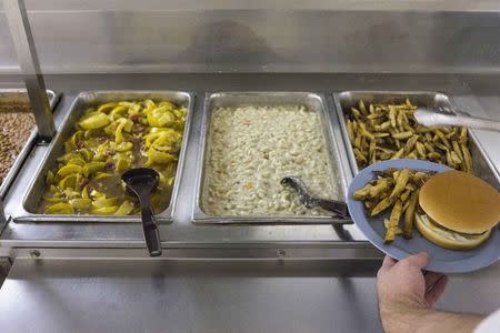 An offender grabs lunch from a cafeteria inside the Darrington Unit of the Texas Department of Criminal Justice men's prison in Rosharon, Texas August 12, 2014. REUTERS/Adrees Latif