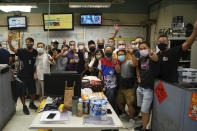 Staff members from the spot news group pose for a photo on their last day in the Apple Daily headquarters in Hong Kong, Wednesday, June 23, 2021. Hong Kong's pro-democracy Apple Daily newspaper will stop publishing Thursday, following last week's arrest of five editors and executives and the freezing of $2.3 million in assets under the city's year-old national security law. (AP Photo/Kin Cheung)