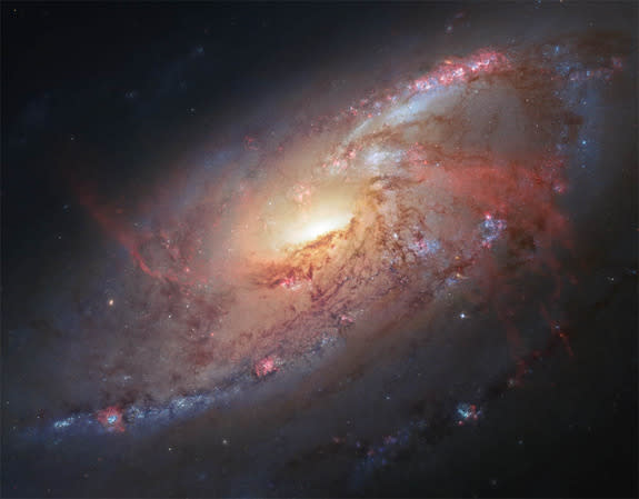 This image combines Hubble observations of the nearby spiral galaxy Messier 106 with additional data captured by amateur astronomers Robert Gendler and Jay GaBany. The galaxy lies about 20 million light-years away, and harbors a giant central b