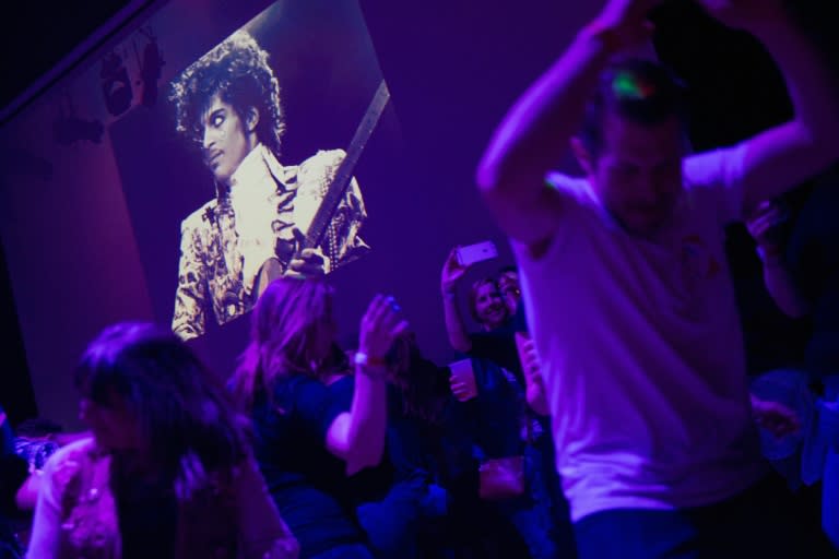 Le chanteur américain Prince, dont des images sont projetées dans une discothèque de Minneapolis, aux Etats-Unis, le 21 avril 2016, jour de son décès dans cette ville. On le voit portant la fameuse chemise à jabot vendue aux enchères le 16 novembre 2023 pour plus de 33.000 dollars (SCOTT OLSON)