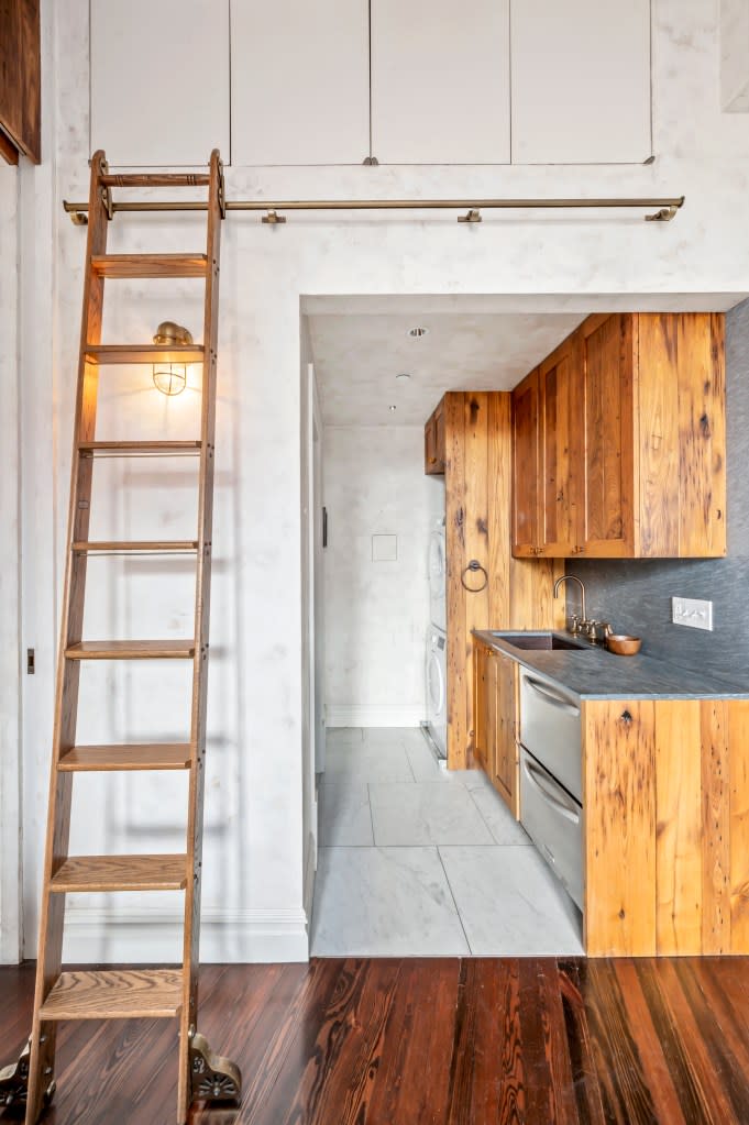 A view of the kitchen and a rolling library ladder that leads to loft-like storage. Carli Choi