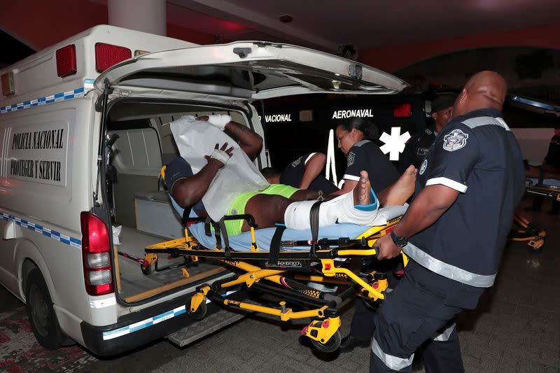 An injured inmate is carried on a stretcher into a hospital by police paramedics after a shootout among inmates at La Joyita prison, in Panama City