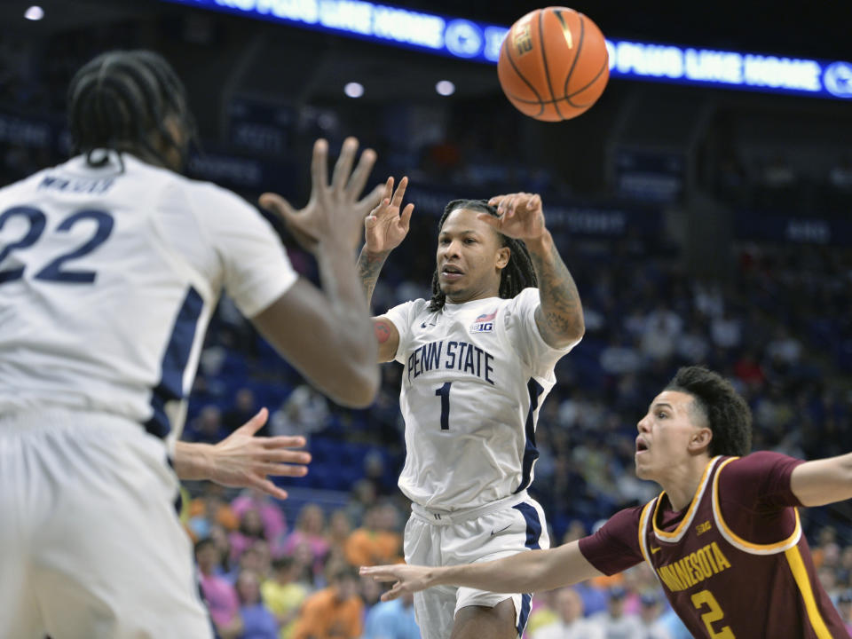 Penn State's Ace Baldwin Jr. (1) dishes off a pass to Qudus Wahab (22), past Minnesota's Mike Mitchell Jr. during the first half of an NCAA college basketball game Saturday, Jan. 27, 2024, in State College, Pa. (AP Photo/Gary M. Baranec)