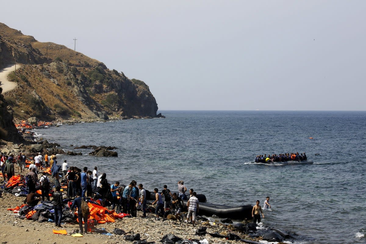 Migrants and refugees onboard a dinghy approach the Greek island of Lesbos (Yannis Behrakis/Reuters)