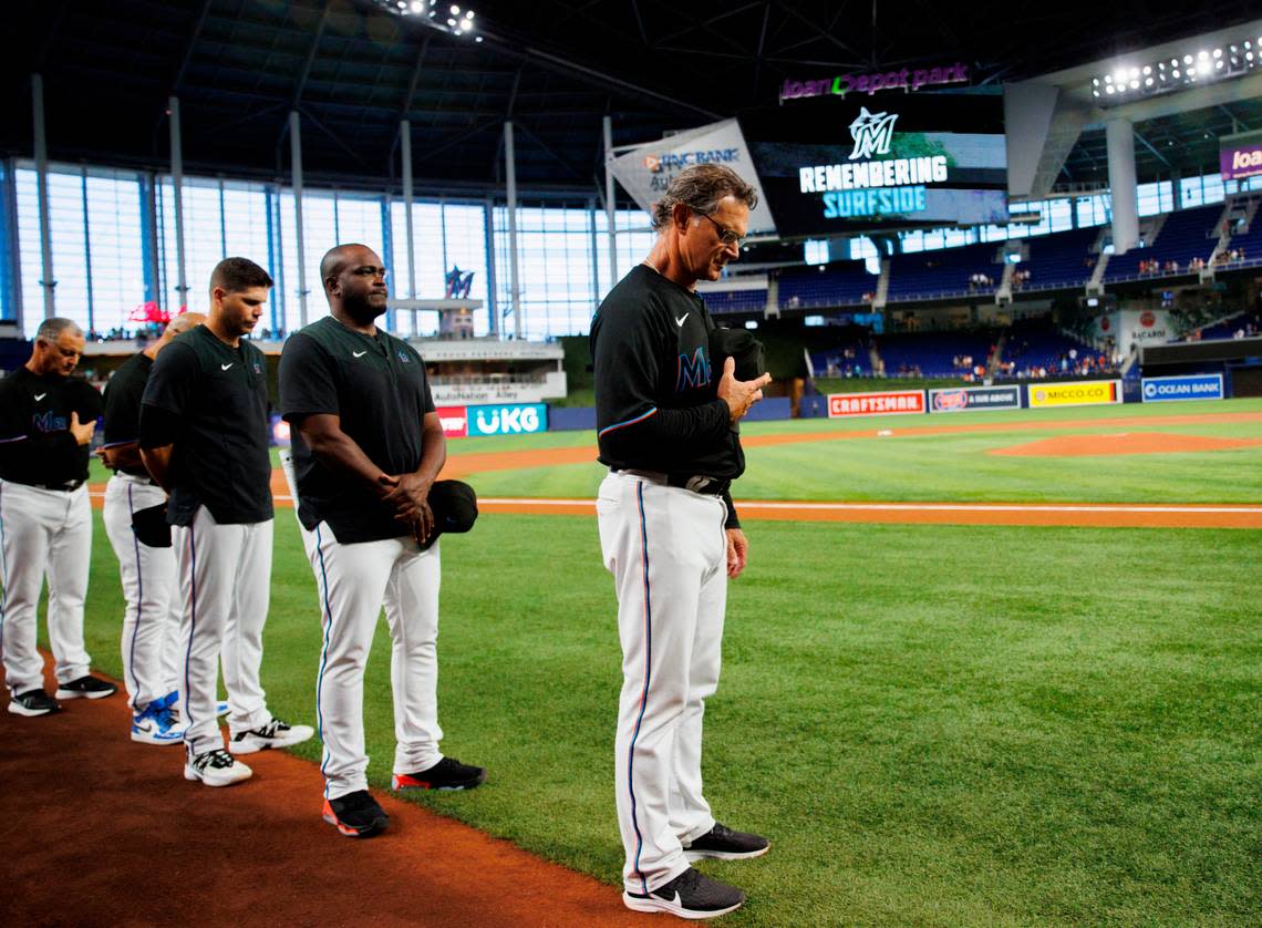 Miami Marlins manager Don Mattingly (8) stand alongside players and coaching staff for a moment of silence to remember the victims of the Surfside building collapse before the start of a baseball game between the Miami Marlins against the New York Mets at LoanDepot Park on Friday, June 24, 2022 in Miami, Florida.