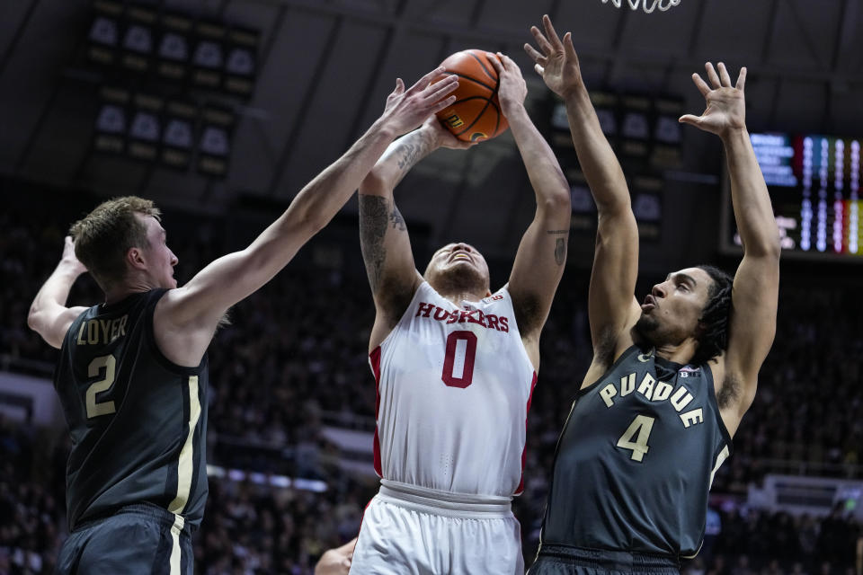 Nebraska guard C.J. Wilcher (0) shoots between Purdue guard Fletcher Loyer (2) and forward Trey Kaufman-Renn (4) during the first half of an NCAA college basketball game in West Lafayette, Ind., Friday, Jan. 13, 2023. (AP Photo/Michael Conroy)