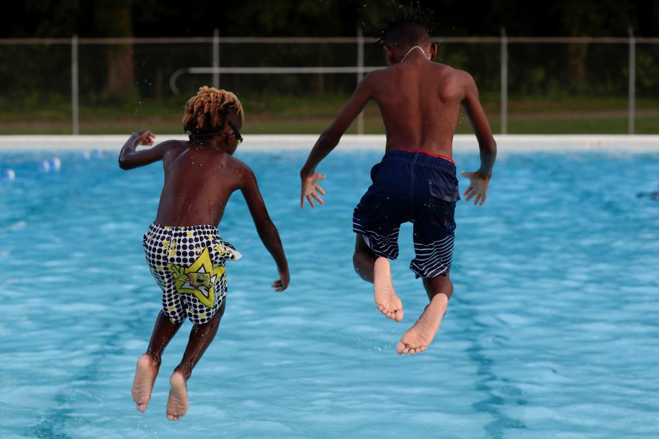 Mazi Dugan, 6, left, and Stanley Adams, 10, right, jump into the pool together during Splash and Jam at the Walker-Ford Community Center Friday, July 26, 2019. 