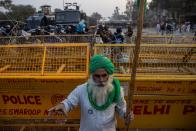 Un agricultor permanece delante de una barricada colocada por la policía india durante una protesta en Singhu. (Foto: Danish Siddiqui / Reuters).