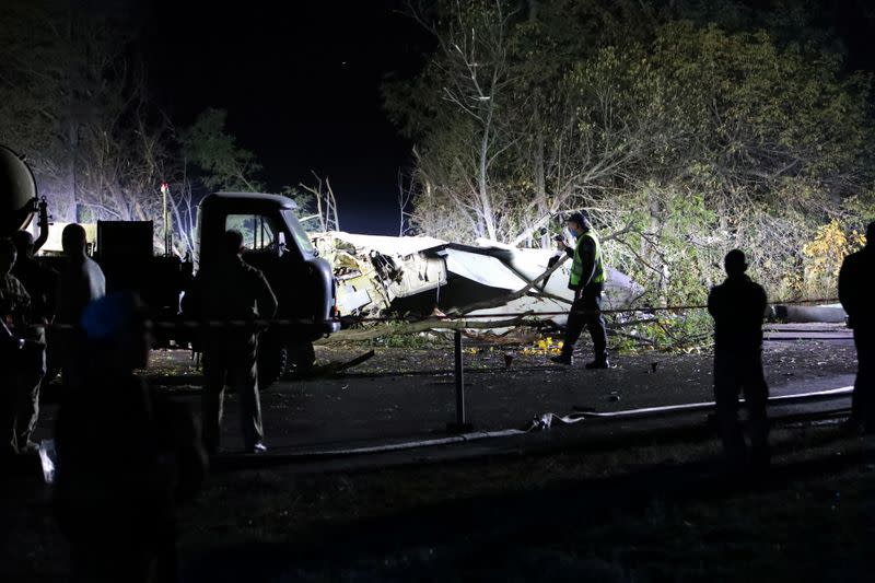 Rescuers inspect wreckages of the Ukrainian military Antonov An-26 plane after crashing outside of Chuhuiv town