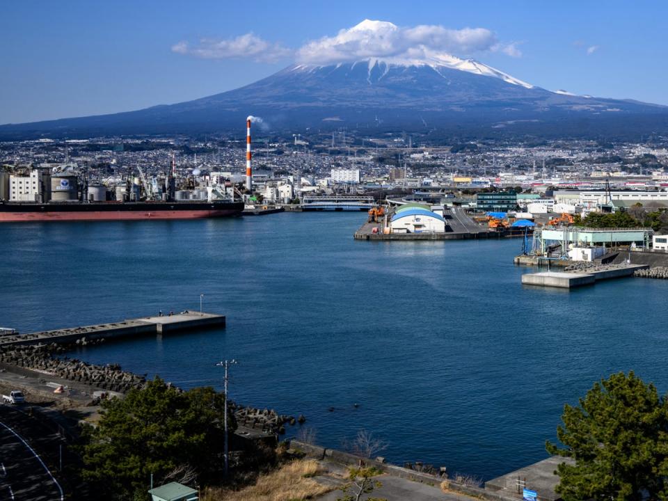 Mount Fuji rises behind industrial facilities at Tagonoura Port in Fuji city, Shizuoka prefecture (Getty)