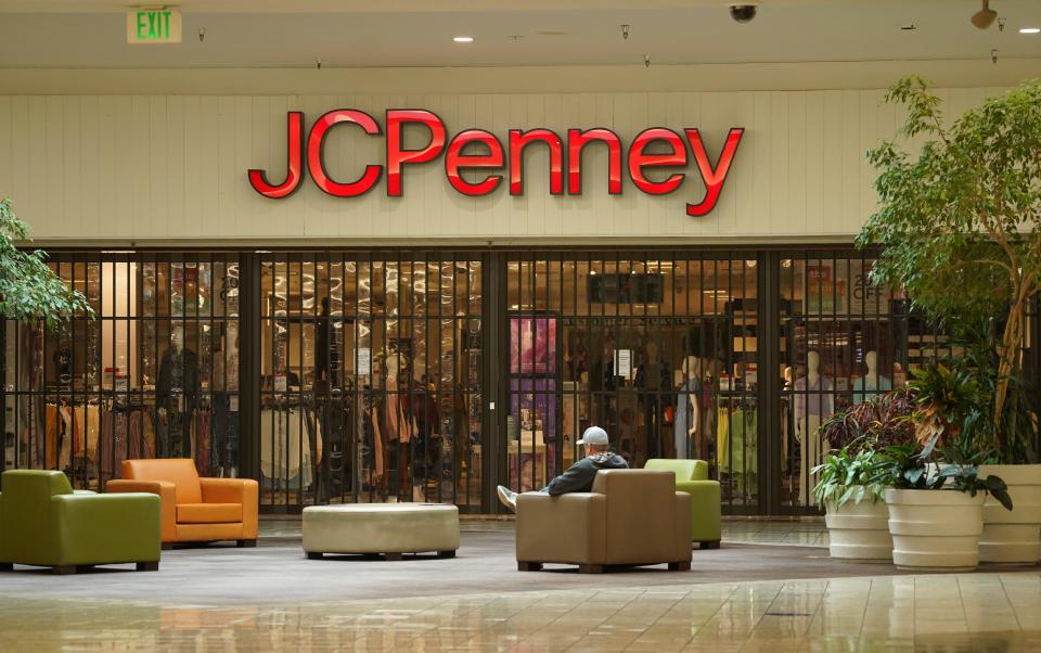 A man sits near the front entrance to the JCPenney store at the Mt. Shasta Mall on Monday, May 18, 2020. It was the mall's first day reopening, about two months since it closed due to the COVID-19 pandemic. Macy's has reopened.