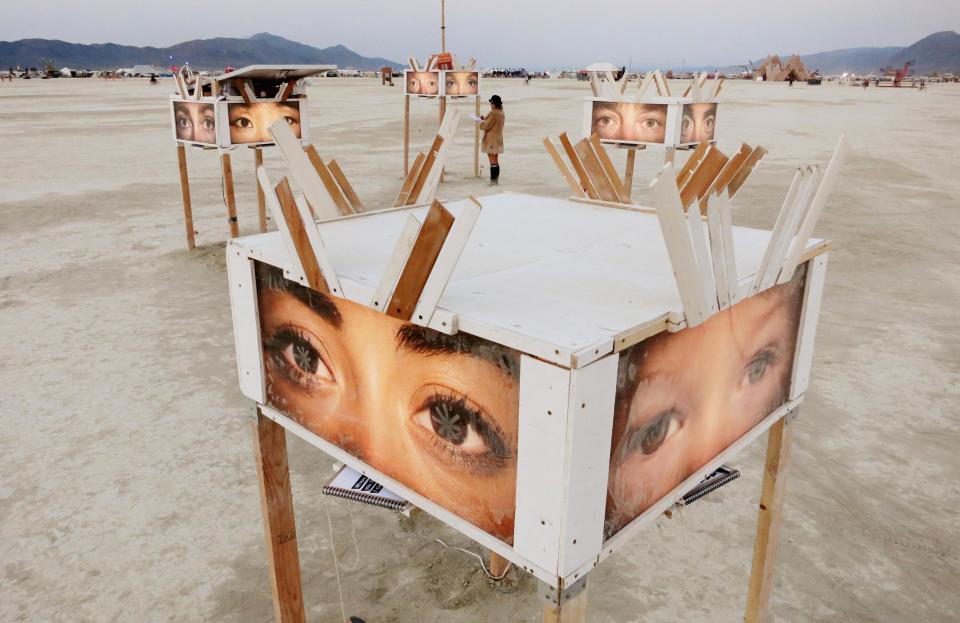 A participant looks at art works on the playa at sunrise, during the 2013 Burning Man arts and music festival in the Black Rock desert of Nevada