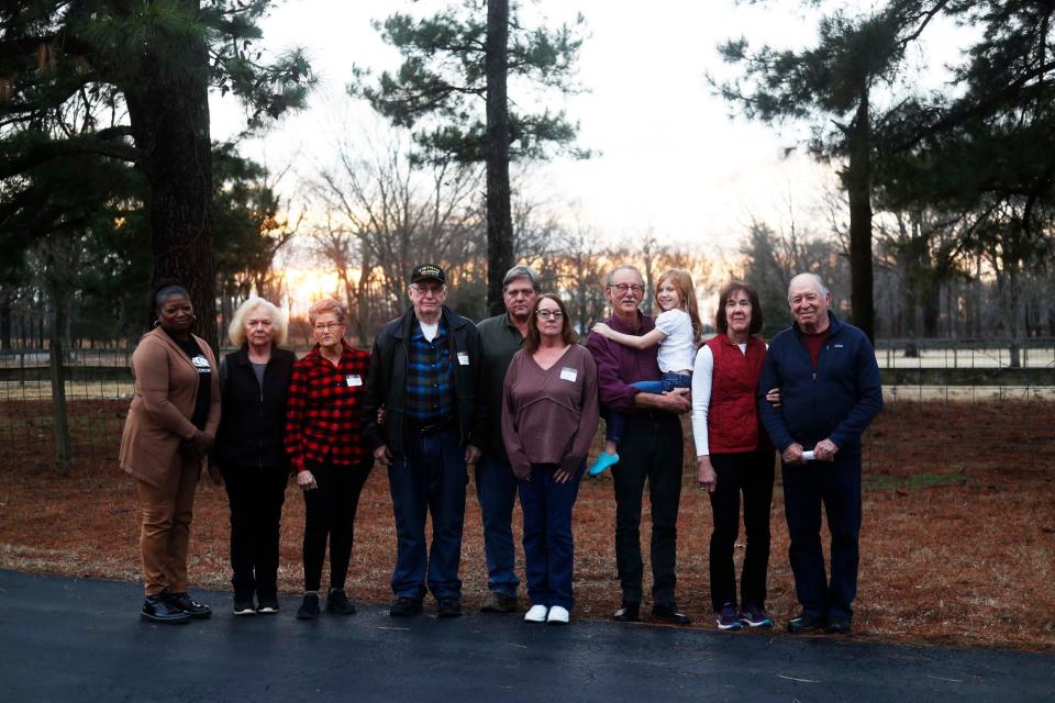 Residents pose for a photo after they gathered to discuss why they are opposed to a solar farm being built in their neighborhood and listed the track record of how these things go when the company is not longer observing the solar farm at one of the resident’s home on Friday, Jan. 26, 2024 in Millington, Tenn.