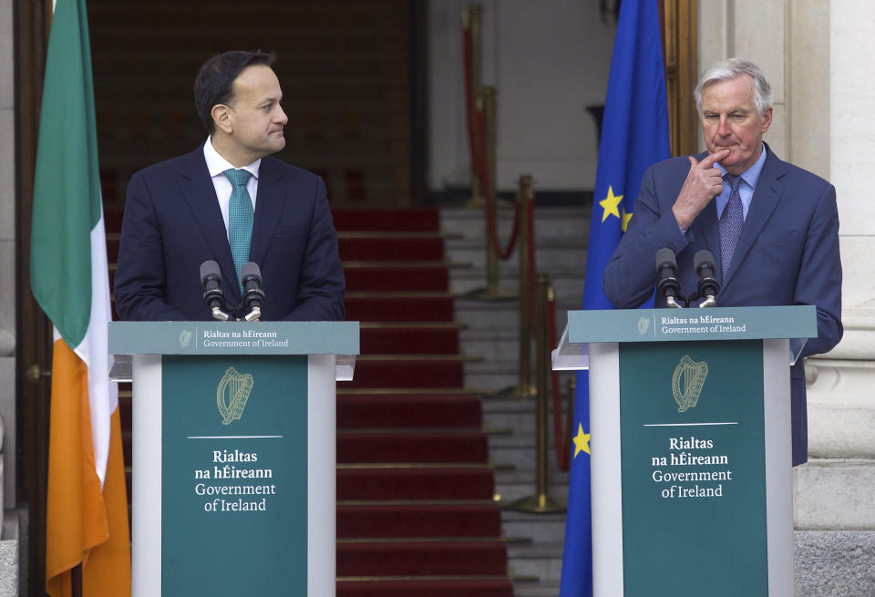 Taoiseach Leo Varadkar, left listens to Michel Barnier, the EU's Brexit negotiator, during a press conference, outside the Government Buildings in Dublin, Monday, Jan. 27, 2020. Ireland’s prime minister has warned Britain that Brexit is far from finished -- and the European Union will have the upper hand in upcoming negotiations on future relations between the two sides. (Damien Eagers/PA via AP)