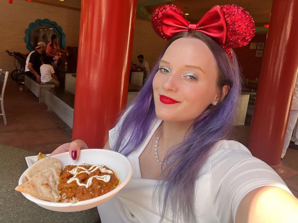 jenna posing with a bowl of chicken tikka masala at the epcot food and wine festival