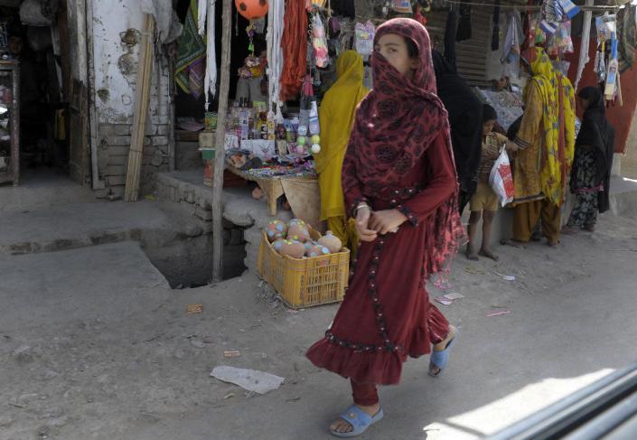 A woman walks through a market on July 28, 2014 in Quetta, Baluchistan province, where acid attacks on female pedestrians have been reported (AFP Photo/Banaras Khan)