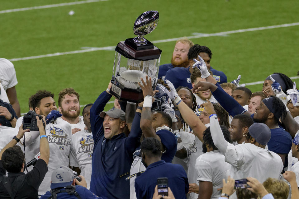 Georgia Southern coach Chad Lunsford and players hold the trophy after a victory over Louisiana Tech in the New Orleans Bowl NCAA college football game in New Orleans, Wednesday, Dec. 23, 2020. (AP Photo/Matthew Hinton)