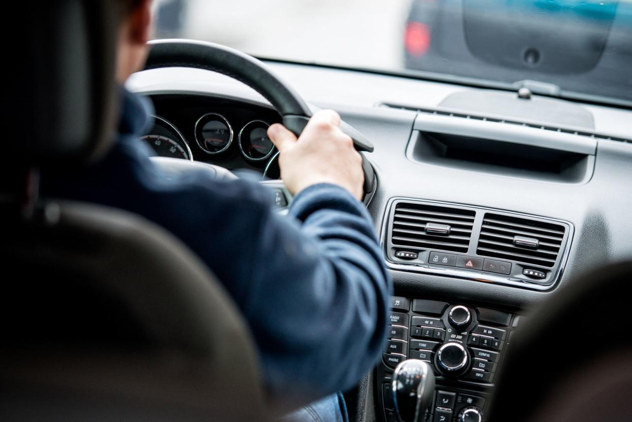 Man, driving a car.