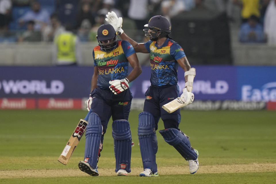 Sri Lanka's Chamika Karunaratne, right, pats to applaud batting partner Bhanuka Rajapaksa as they leave the field at the end of their innings during the T20 cricket Asia Cup final match between Pakistan and Sri Lanka, in Dubai, United Arab Emirates, Sunday, Sept. 11, 2022. (AP Photo/Anjum Naveed)
