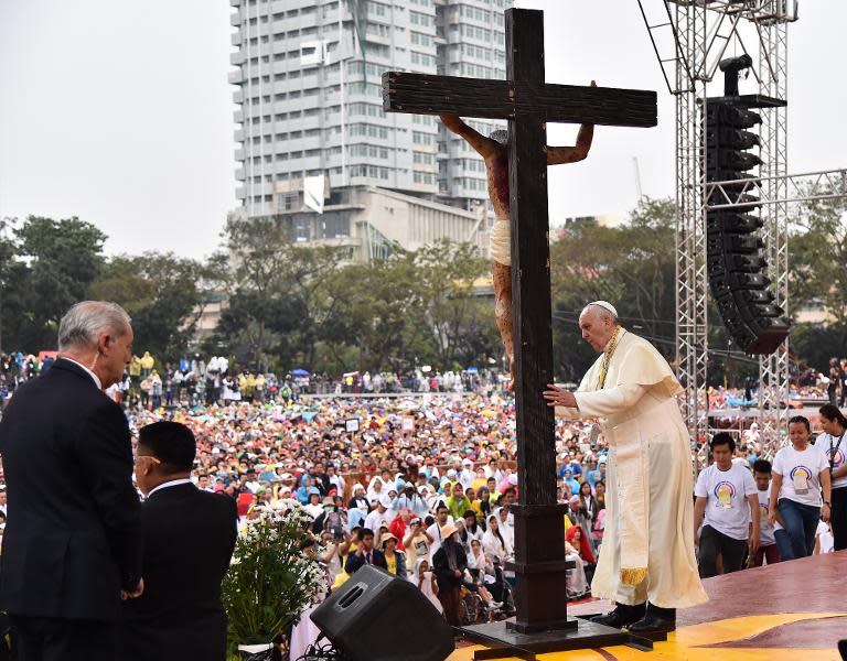 Pope Francis prays in front of a cross during his visit to the University of Santo Tomas, in Manila, on January 18, 2015