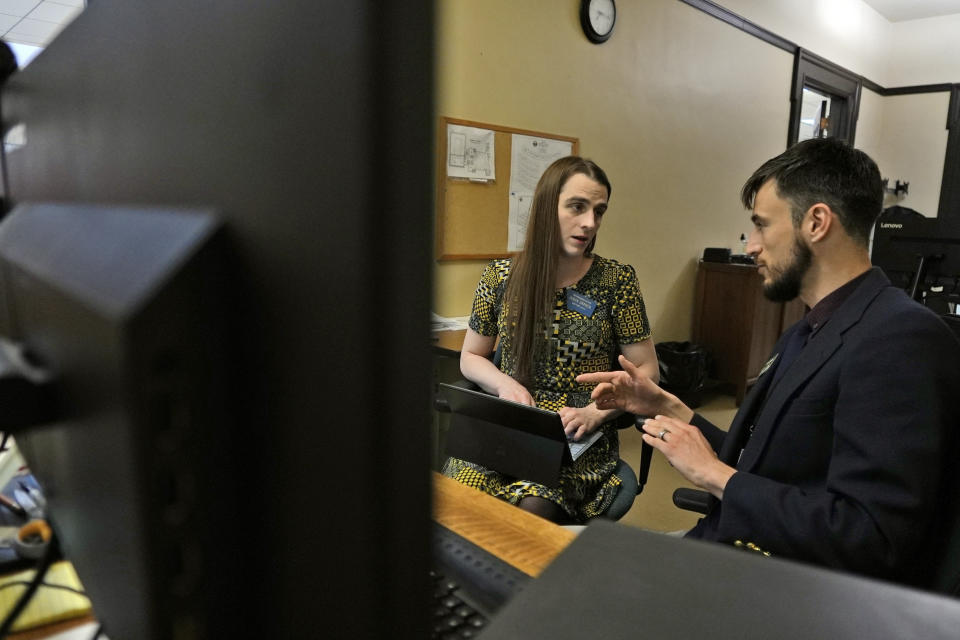 State Rep. Zooey Zephyr,left, speaks with an IT specialist to prepare for her first day of remote voting at the State Capitol, Thursday, April 27, 2023 in Helena, Mont. Zephyr was barred from participating on the House floor as Republican leaders voted Wednesday to silence her for the rest of 2023 session after she protested GOP leaders' decision earlier in the week to silence her. (AP Photo/Brittany Peterson)