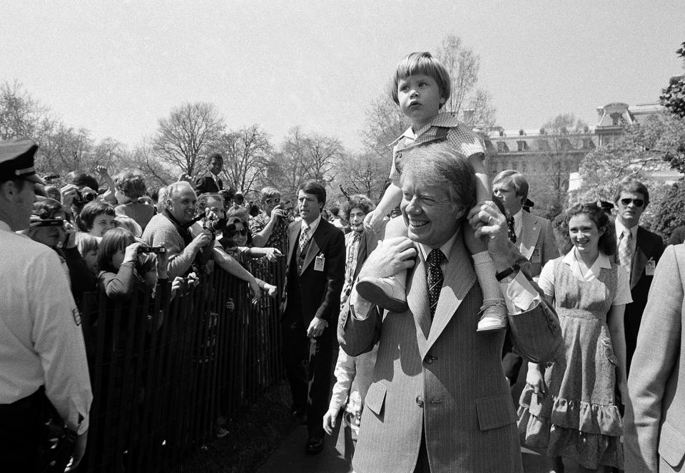 <p>President Jimmy Carter holds grandson Jason Carter, 2, on his shoulders while visiting the South Lawn on Monday, April 11, 1977, site of the Easter Egg Roll at the White House in Washington. (Photo: AP) </p>