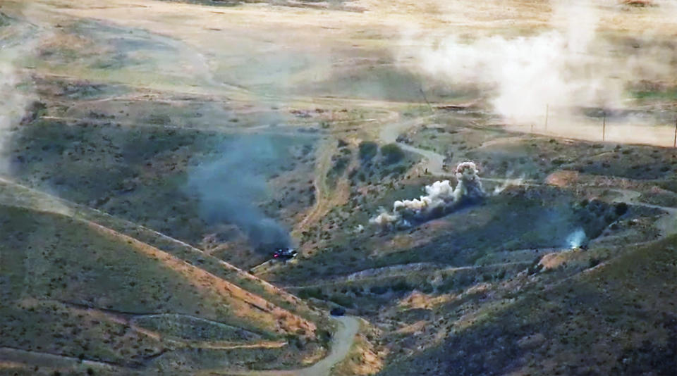 In this image taken from a video released by Armenian Defense Ministry on Sunday, Oct. 4, 2020, Armenian artillery attack Azerbaijan's troops at the contact line of the self-proclaimed Republic of Nagorno-Karabakh, Azerbaijan. The fighting, which broke out on Sept. 27 and has continued for eight straight days, is the biggest escalation in years in the decades-long dispute over Nagorno-Karabakh. The region lies within Azerbaijan, but is controlled by local ethnic Armenian forces backed by Armenia. (Armenian Defense Ministry via AP)