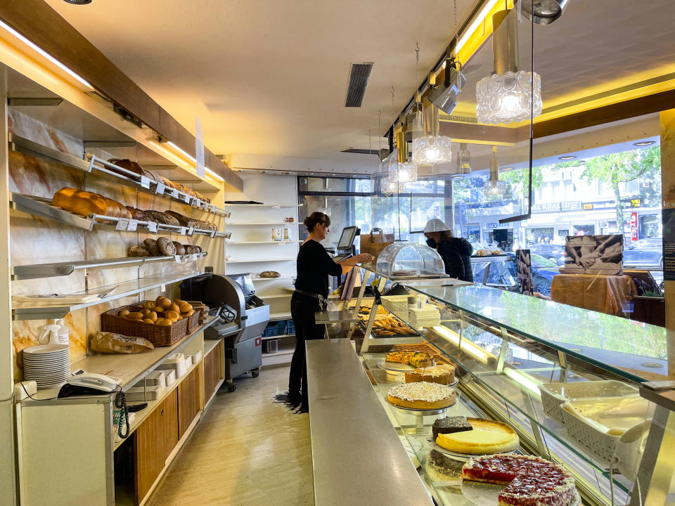 An employee serves a customer at the family bakery of Engelbert Schlechtrimen in Cologne, Germany, Wednesday, Sept. 21, 2022. For 90 years, the family of Engelbert Schlechtrimen has been baking wheat rolls, rye bread, apple, cheese and chocolate cakes in Cologne, but next month they'll turn off the ovens for good because they can no longer afford the rising energy prices resulting from Russia's war in Ukraine. (AP Photo/Daniel Niemann)