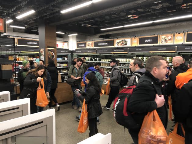 People move about the first cashier-free Amazon Go store on opening day in Seattle in January. (GeekWire Photo / Todd Bishop) <strong><a href="https://www.geekwire.com/2018/check-no-checkout-amazon-go-automated-retail-store-will-finally-open-public-monday/" rel="nofollow noopener" target="_blank" data-ylk="slk:Read the story.;elm:context_link;itc:0;sec:content-canvas" class="link ">Read the story.</a></strong>