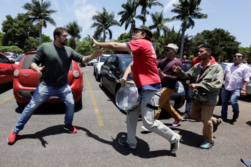 A supporter of Venezuela's President Nicolas Maduro fights with an opposition leader Juan Guaido's supporter outside the Venezuelan embassy in Brasilia