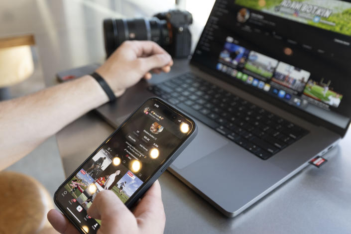 Adam Botkin, a football TikTok influencer, edits a video for a post at a Chipotle Mexican Grill while eating dinner in Missoula, Mont., on Wednesday, May 3, 2023. Botkin, a former walk-on place kicker and punter for the Montana Grizzlies, gained notoriety on the social media platform after videos of him performing kicking tricks went viral. (AP Photo/Tommy Martino)