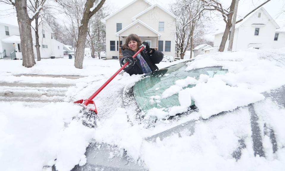 Jeannie Garcia removes snow from her car on Friday, March 22, 2024, in Ames, Iowa.